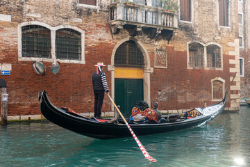 Fototapeta na wymiar Venice, Italy - October 31 2020: Gondola with tourists on Venice canal