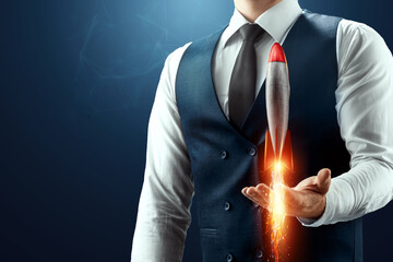 The businessman has a rocket taking off in his palm. The concept of a startup, profit increase,...