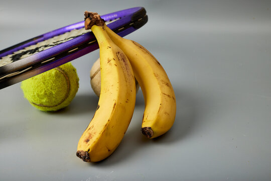 Raqueta de tenis, dos pelotas y dos pl&aacute;tanos