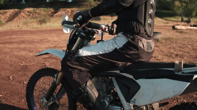 Mid-section Slowmo Shot Of Unrecognizable Man In Riding Gear Mounting Motorcycle And Driving Away