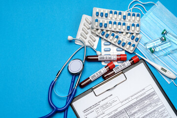 Clipboard with paper blank form with medical tools on blue background with cope space