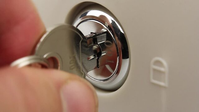 human try to open lock of safe or cash drawer with key, gets stuck and it is difficult to turn the key in the lock, lock is broken or the mechanism is defective, close-up view
