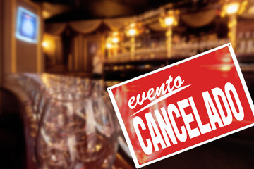 EVENT CANCELLED sign saying in spanish, Empty restaurant with text Event cancelled due to quarantine restriction, precautions during a pandemic, fighting covid virus, social distancing