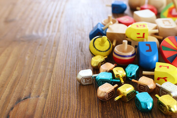 image of jewish holiday Hanukkah with wooden dreidels (spinning top) over wooden background