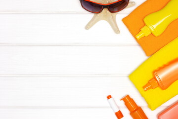 Sunscreen cosmetic products on white wood background. Flat lay. Copy space. Sun safety cosmetics concept