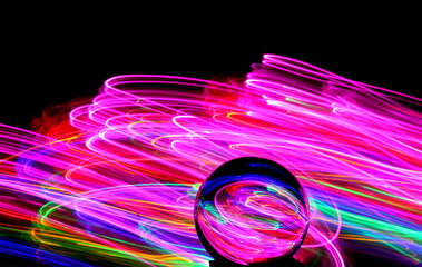 Long exposure photograph of neon multi colour in an abstract swirl, parallel lines pattern against...