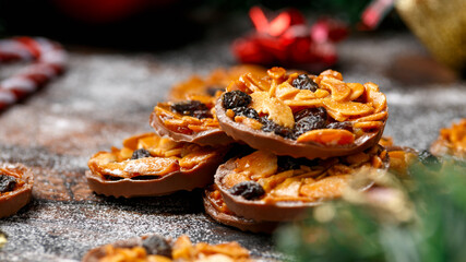 Christmas Chocolate Florentines cookies with almond and raisins with decoration, gifts, green tree...