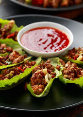 Chilli Beef Lettuce Wraps with sauce on black plate