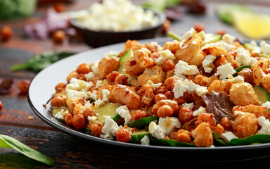 Roasted Cauliflower salad with chickpea, cucumber, greens and feta cheese. healthy food