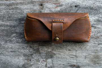 Brown genuine leather glasses handmade case on wood background