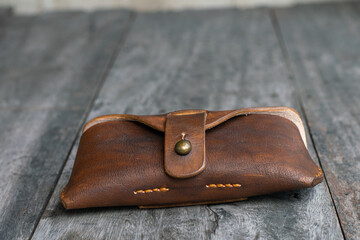 Brown genuine leather glasses handmade case on wood background