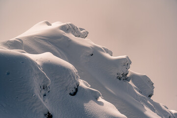 Isolated rock covered by snow in winter. Glaciers 3000, Diablerets in Switzerland.
