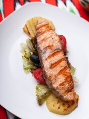 Salmon steak on a pillow of stewed vegetables. Asian style