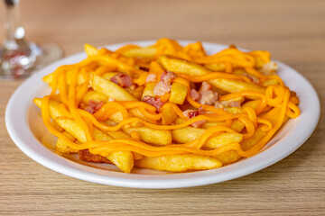 Batata frita com cheddar e pedaços de bacon