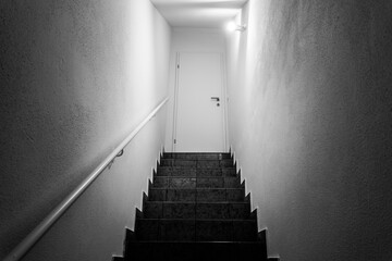 Basement stairway with railing. White door closed - 396109869