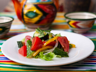 Vegetable salad of tomatoes, cucumbers, herbs and sweet pepper with butter. Asian style