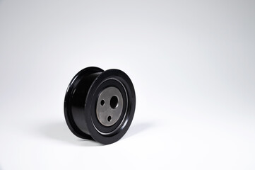 New timing belt tensioner roller close-up macro shot on gray background