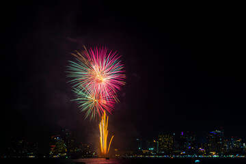 Firework festival with beach foreground and city background at Pattaya beach, Thailand. Colorful...