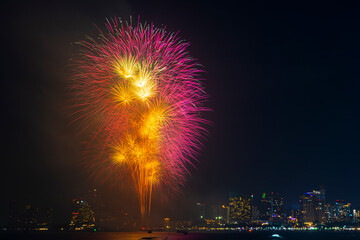 Firework festival with beach foreground and city background at Pattaya beach, Thailand. Colorful firework in celebration festival background