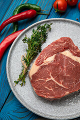 Raw Meat Sliced Pieces Of Beef With Spices And Herbs on a round plate