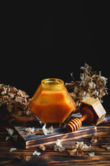 honey in jar around flowers.