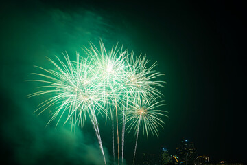 Firework festival with beach foreground and city background at Pattaya beach, Thailand. Colorful firework in celebration festival background