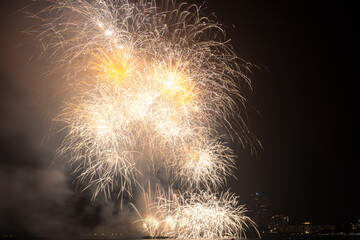 Firework festival with beach foreground and city background at Pattaya beach, Thailand. Colorful...