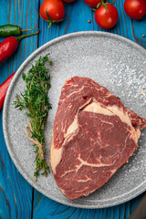 Raw Meat Sliced Pieces Of Beef With Spices And Herbs on a round plate