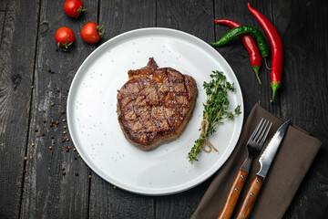 grilled steak on a white round plate.
