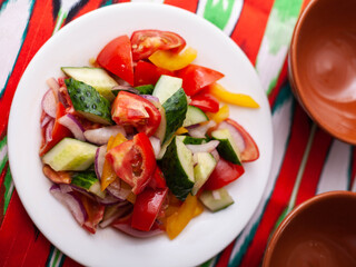 Tomato, cucumber, sweet pepper and onion salad, seasoned with oil. Asian style