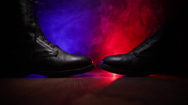 War concept. Old military shoe in a dark toned foggy background. Creative concept of conflict between countries, military aggression. Selective focus