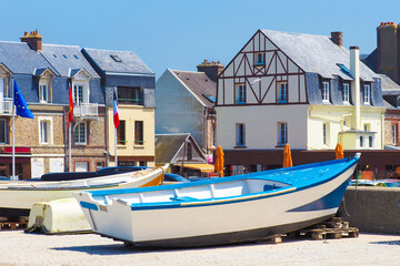 Fototapeta na wymiar Picturesque landscape beautiful city of Etretat of Normandy, France. Fishing boats near country houses