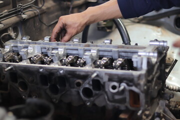 The mechanic is checking the engine.