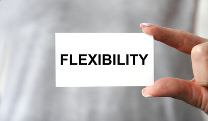 The girl holds a card with the text FLEXIBILITY in front of her.