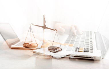 Justice and law concept.Male judge in a courtroom with the gavel, working with, computer and docking keyboard, eyeglasses, on table in morning light