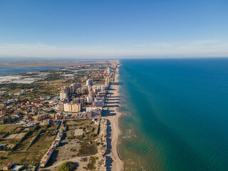 Obraz premium Aerial shot of a long sandy beach and buildings on a sunny day near Valencia, Spain