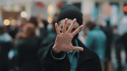 Stop. Young woman with face mask stoping camera with outstretched hand. Demonstation and protest. High quality 4k footage
