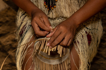 Hands of indigenous woman from the Huitoto tribe of the Colombian Amazon making traditional weaving...