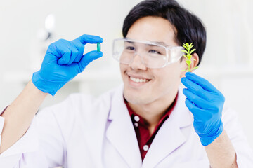 Asian scientist medical researcher successful extract medicine from green plant at biomedical laboratory.