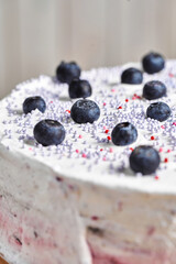 Cake with berries. Board with delicious tasty homemade cake on table. Wooden background.