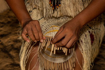 Hands of indigenous woman from the Huitoto tribe of the Colombian Amazon making traditional weaving...