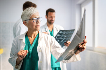 Doctors discussing patient's diagnosis looking at x-rays in a hospital
