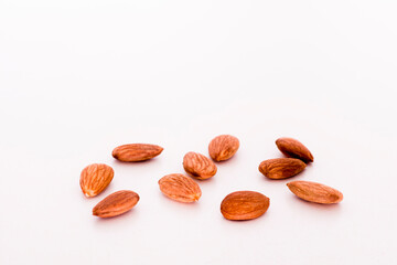 Some isolate Almonds on a white table.