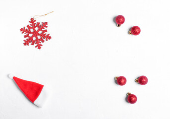 Christmas background on white. Red snowflake, baubles and santa hat. Copy space