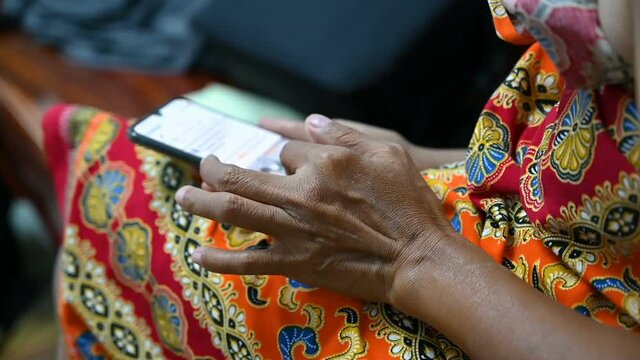 Elderly women hands hold use slide mobile smartphones touchscreen displays closeup surfing in social media and messenger.