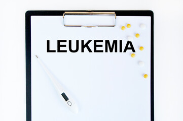On the tablet for the letter text LEUKEMIA, next to the thermometer and yellow tablets.