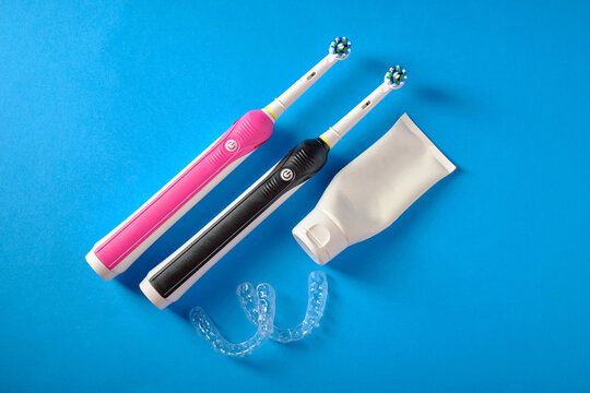 Electric toothbrushes, toothpaste, plastic mouthguards, on a blue background, top view