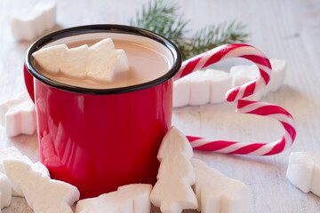 Mug of Christmas cocoa with marshmallows in shape Christmas trees and candy canes 