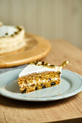 Slice of Carrot cake on plate. Board with delicious tasty homemade cake on table. Wooden background.