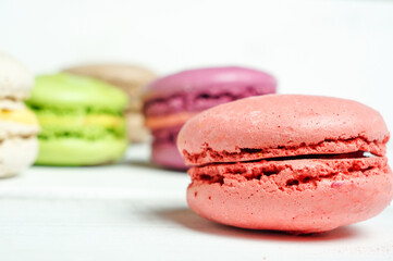 Set of colorful French pasta cakes.  Sweet macaroons with different flavors on a white wooden table...